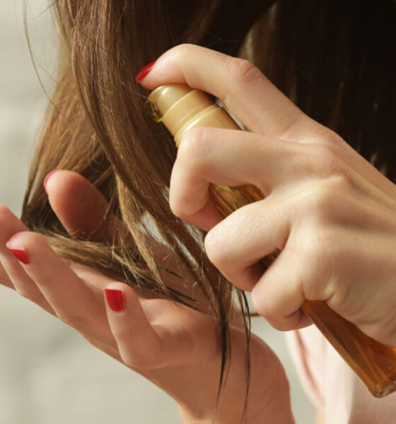 Manos rocian un líquido para aclarar el cabello de manera natural.