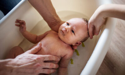 Manos lavan y bañar a un bebé recién nacido. Aprende a los cuántos días se baña un recién nacido.