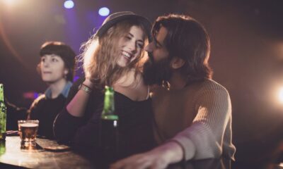 Mujer y hombre jóvenes hablan en un bar. Encuentra mujeres buscando pareja con estos consejos.